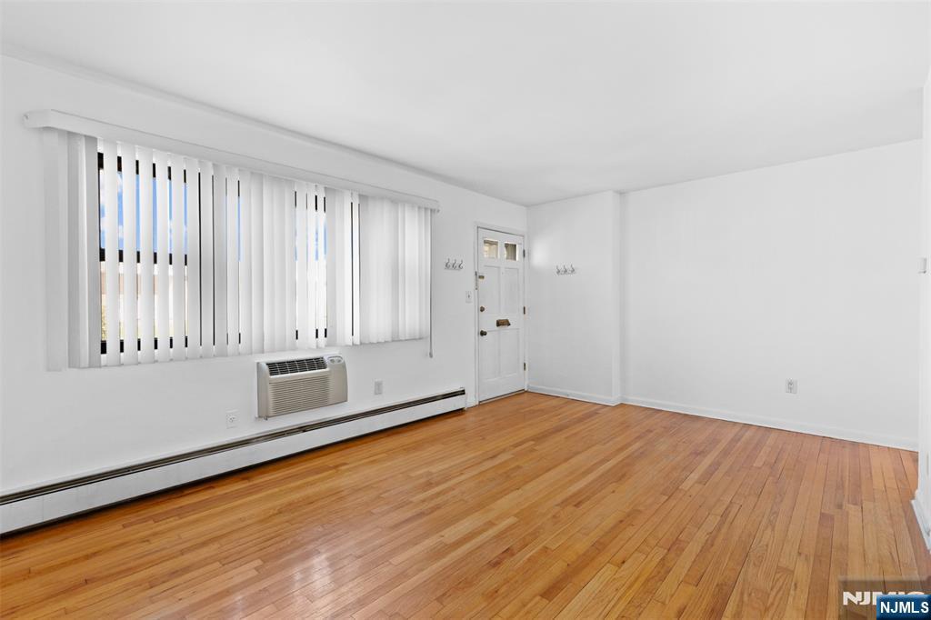 6 Colonial Drive, Unit 6A Little Falls, NJ 07424 - Photo 4 of 44 a view of an empty room with wooden floor and a window