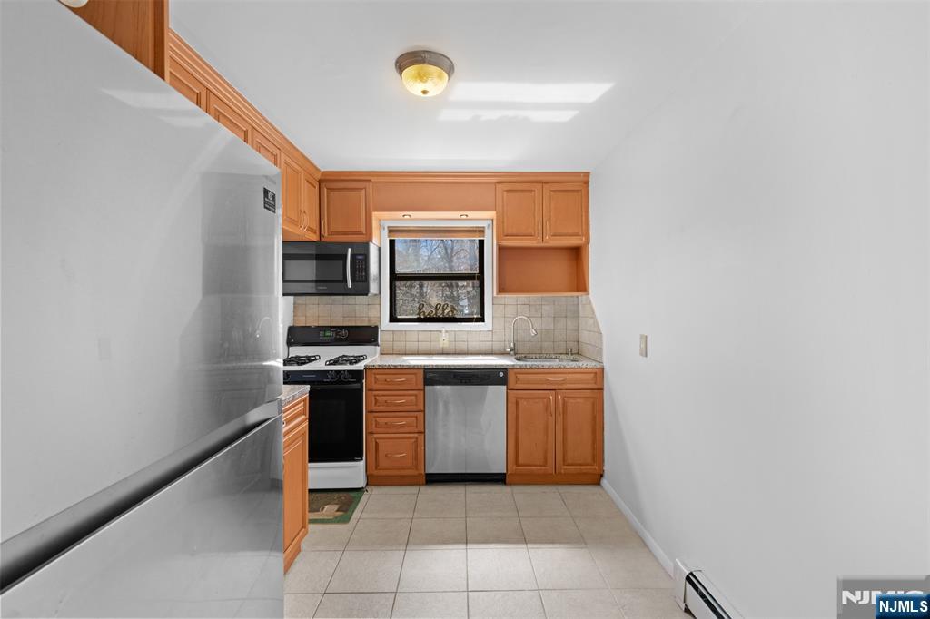 6 Colonial Drive, Unit 6A Little Falls, NJ 07424 - Photo 8 of 44 a kitchen with stainless steel appliances granite countertop a sink and a stove top oven