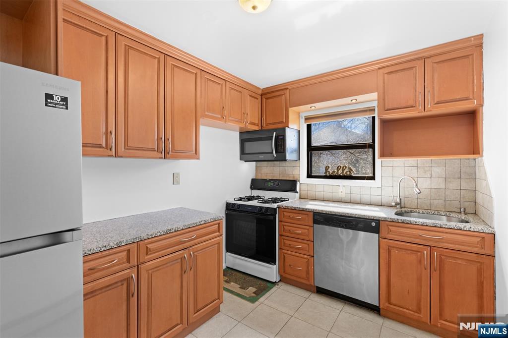 6 Colonial Drive, Unit 6A Little Falls, NJ 07424 - Photo 9 of 44 a kitchen with stainless steel appliances granite countertop a sink stove and microwave