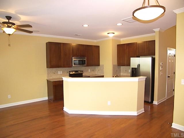 3507 Provost Street Raleigh, NC 27603 - Photo 4 of 12 Austen kitchen/family room pictures are from model. Custom mantel and fireplace, smooth 9' ceilings are std. Upgrades: hdwds, crown molding, stainless appliances, quartz counter tops, bronze fixtures, tile backsplash, and refrigerator.