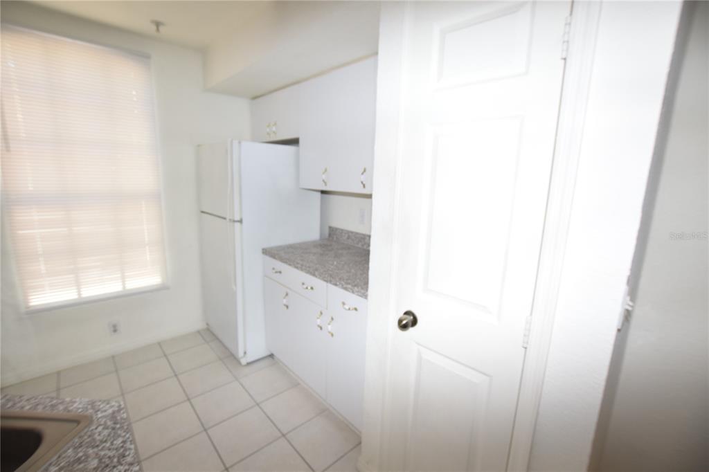6324 Raleigh Street, Unit 714 Orlando, FL 32835 - Photo 15 of 32 a kitchen with white cabinets and window