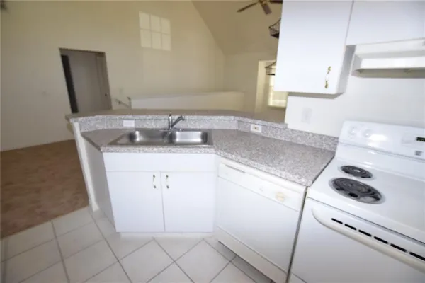 a kitchen with a sink cabinets and white appliances