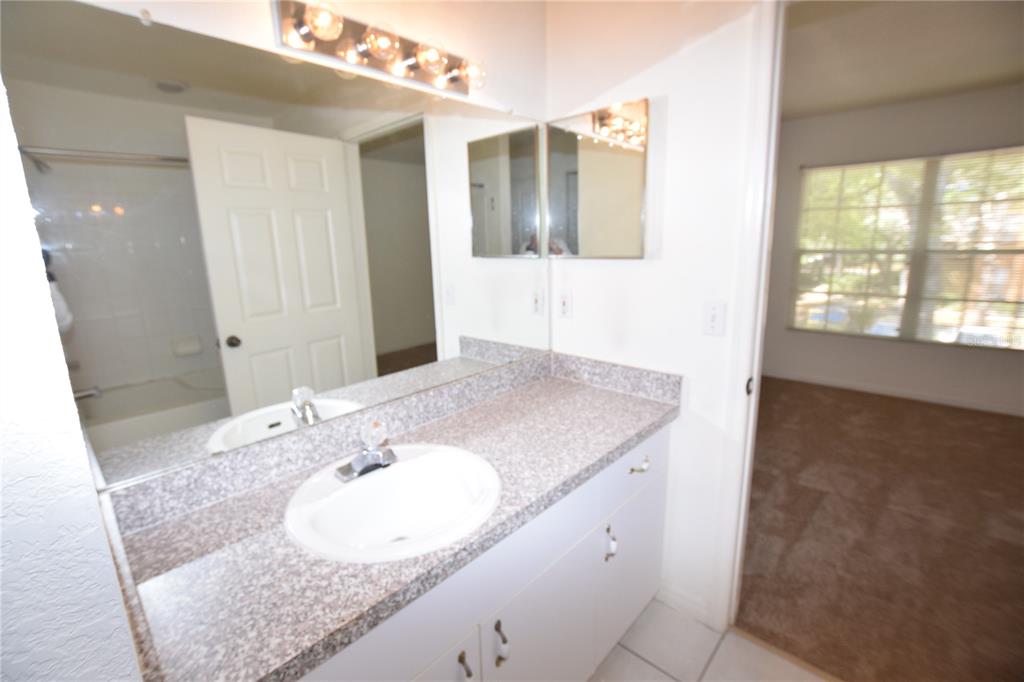 6324 Raleigh Street, Unit 714 Orlando, FL 32835 - Photo 23 of 32 a bathroom with a granite countertop sink and a mirror