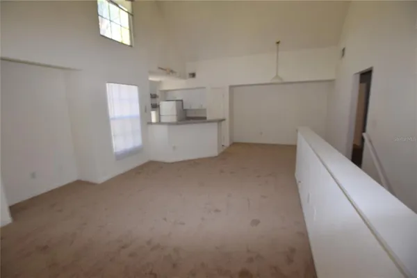 a view of a kitchen with refrigerator and window