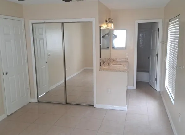 an empty room and a bathroom with mirror