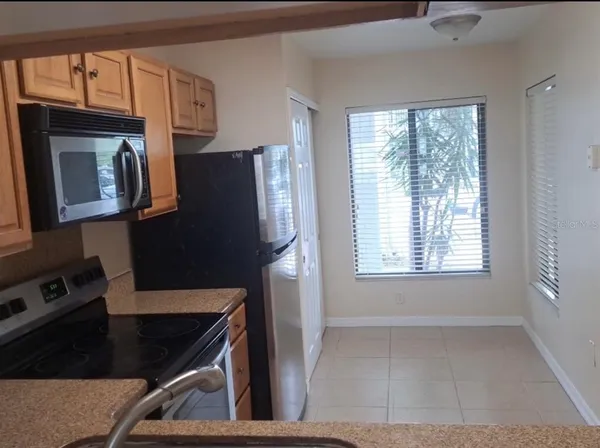 a kitchen with a sink a refrigerator and cabinets