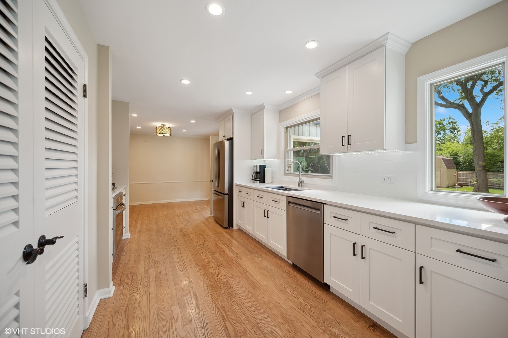 1165 West Deerpath Road Lake Forest, IL 60045 - Photo 6 of 16 a large white kitchen with a refrigerator a sink dishwasher a stove and a refrigerator with wooden floor