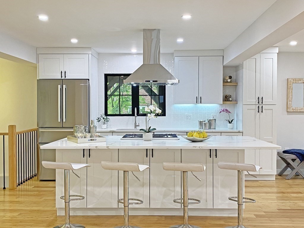 9 Glazer Road, Unit 9 Newton, MA 02459 - Photo 11 of 40 a kitchen with stainless steel appliances granite countertop a table and chairs in it