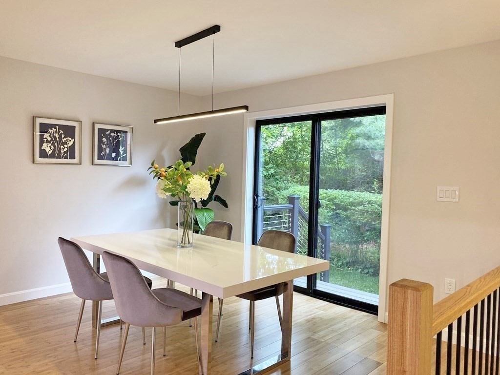 9 Glazer Road, Unit 9 Newton, MA 02459 - Photo 8 of 40 a dining room with furniture potted plants and wooden floor