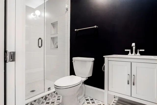 a bathroom with a sink a toilet and shower