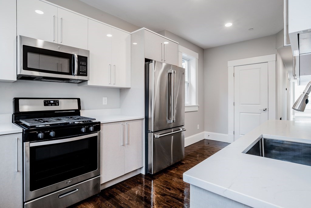 59 Strathmore Road, Unit 2 Boston, MA 02135 - Photo 3 of 13 a kitchen with stainless steel appliances white cabinets and a stove top oven