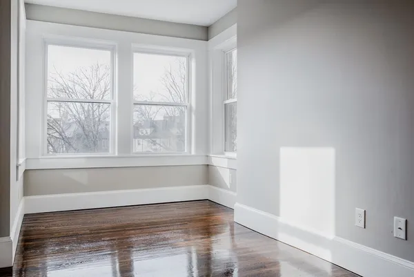 a view of a room with wooden floor and windows