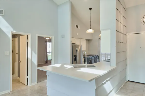 a view of living room with kitchen island and stainless steel appliances