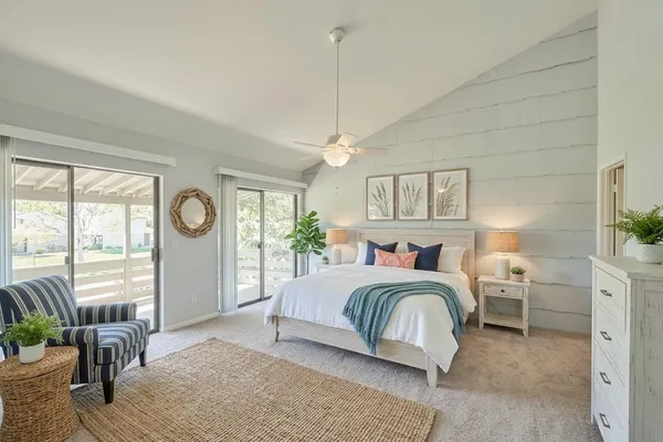 an empty room with chandelier fan and windows