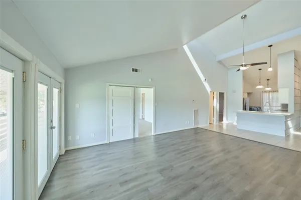 a view of a hallway with wooden floor and a chandelier