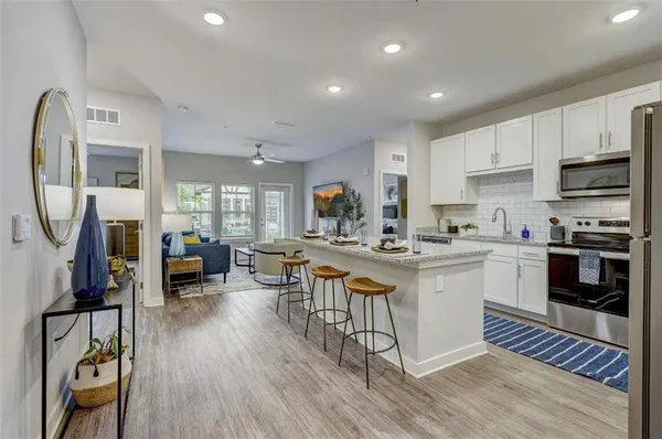 a kitchen with a refrigerator a stove top oven a sink and cabinets