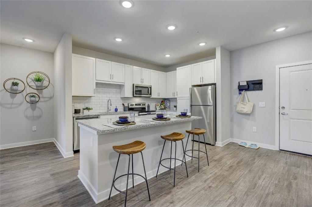 4000 Mill Spring Circle, Unit 4433 Oakwood, GA 30566 - Photo 2 of 28 a kitchen with a refrigerator a stove top oven a sink and cabinets