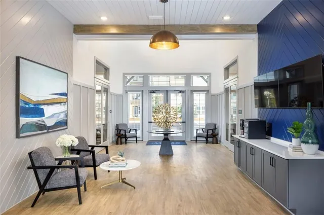 a kitchen with stainless steel appliances a dining table chairs refrigerator and sink