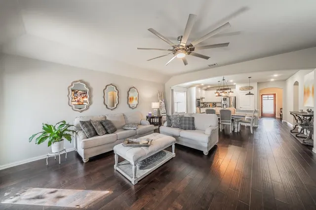 a living room with furniture and a wooden floor