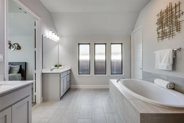 a large white bathroom with a large tub sink and vanity