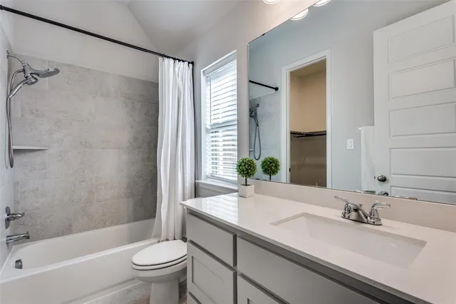 a bathroom with a granite countertop sink a toilet and shower