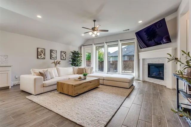 a living room with furniture a flat screen tv and a fireplace