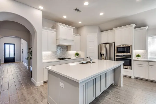 a kitchen with kitchen island a stove a sink and a refrigerator