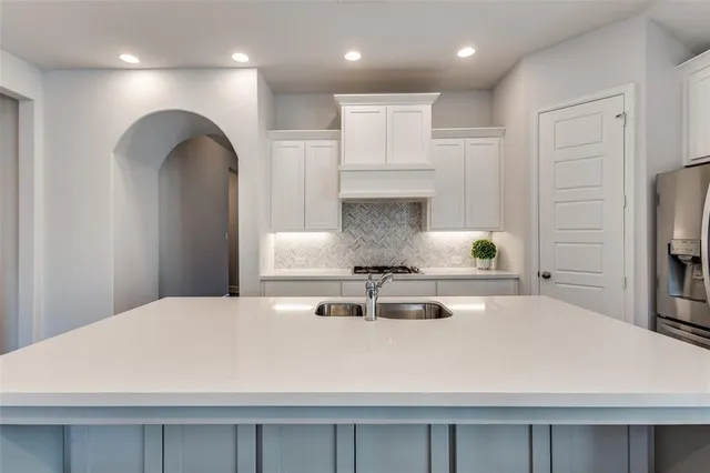 a large white kitchen with stainless steel appliances