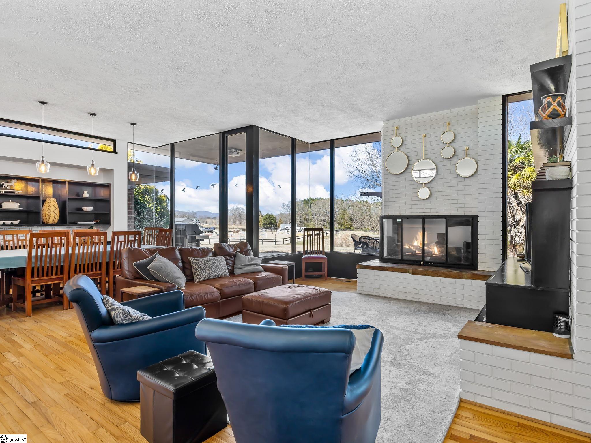 145 Dickson Road Campobello, SC 29322 - Photo 18 of 50 The Great Room features walls of windows to let in the beauty of the surrounding property. Built-in bookcases and shelves, a fireplace, dining and living areas open onto the kitchen giving a wonderful open feel.