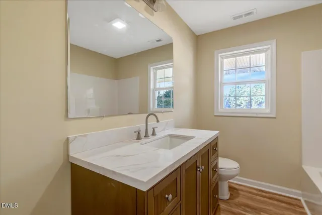 a bathroom with a sink a toilet and a mirror