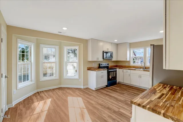 a kitchen with granite countertop a stove top oven sink and cabinets