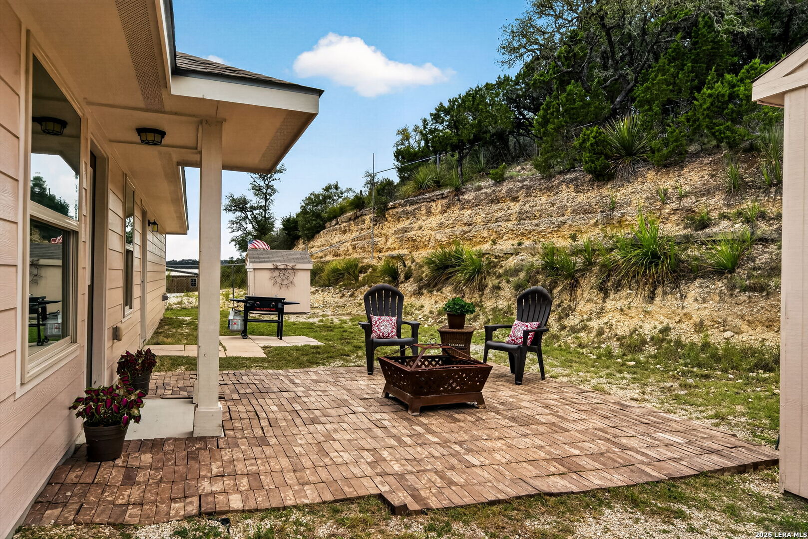 142 Harbour Vw Road Lakehills, TX 78063 - Photo 27 of 38 a view of a patio with table and chairs potted plants with wooden floor and fence
