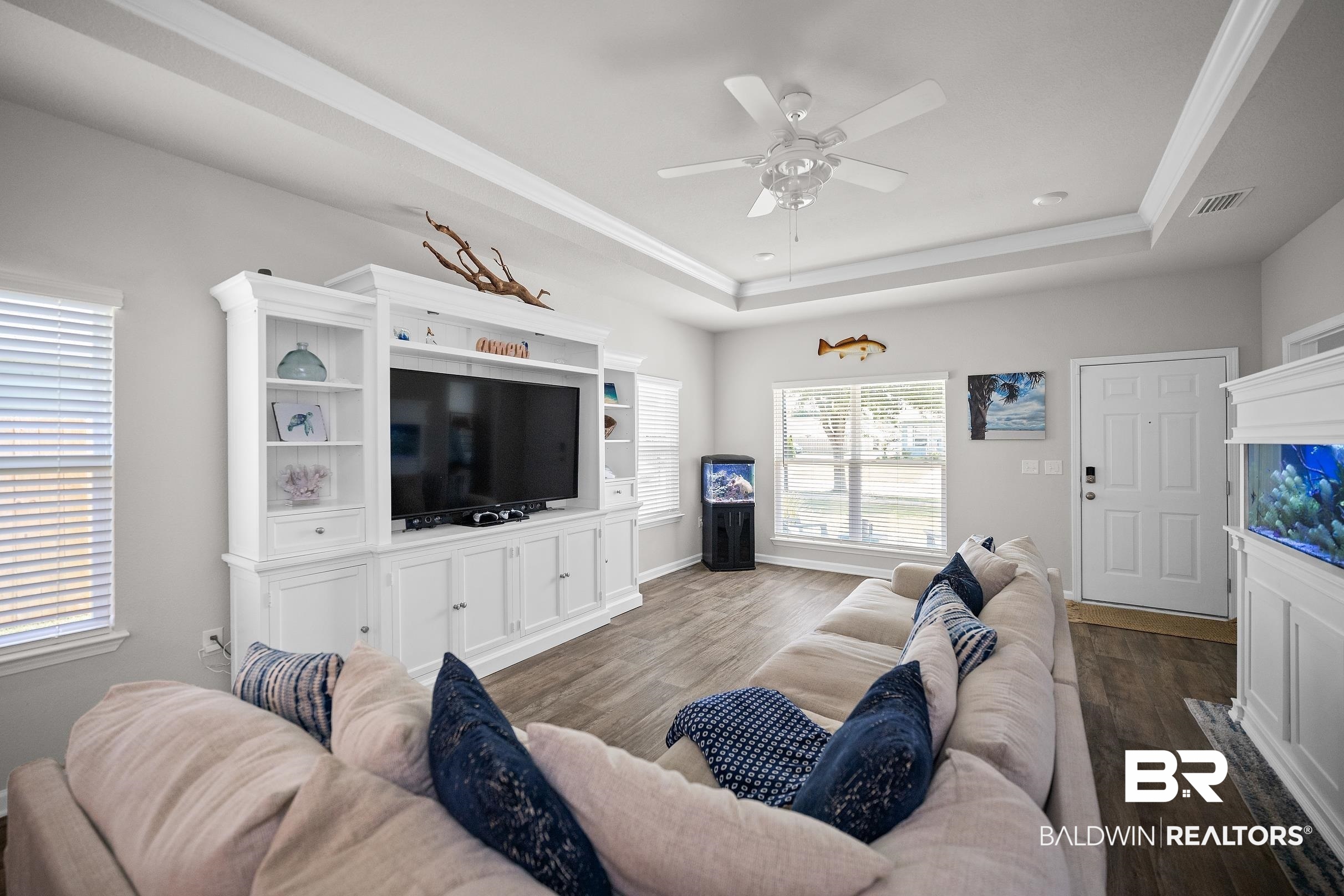 23997 Veranda Circle Elberta, AL 36530 - Photo 2 of 28 Living area featuring wood-finish flooring, white tray ceiling, and a ceiling fan