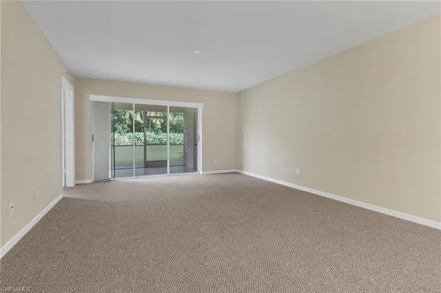 a view of a big room with windows and chandelier fan