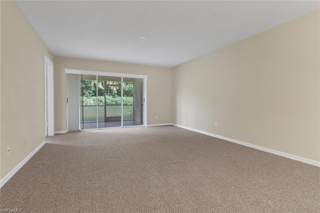 7779 Jewel Lane, Unit 103 Naples, FL 34109 - Photo 12 of 26 a view of a big room with windows and chandelier fan