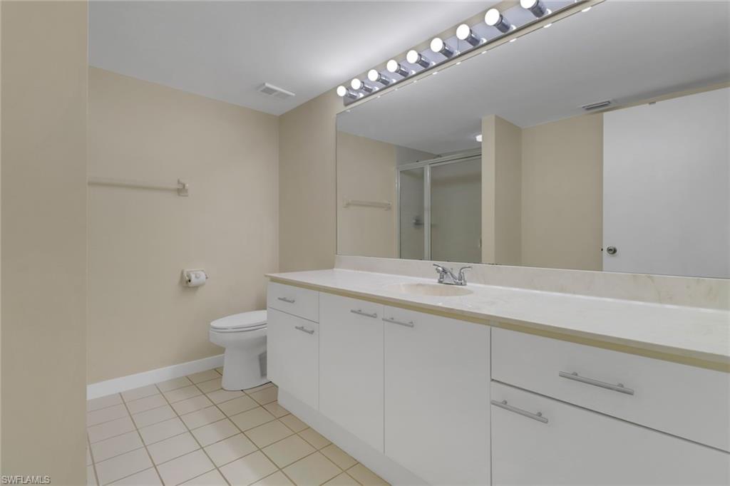 7779 Jewel Lane, Unit 103 Naples, FL 34109 - Photo 17 of 26 a bathroom with a sink a toilet and a mirror