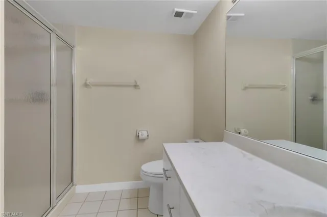 a bathroom with a granite countertop toilet and a shower