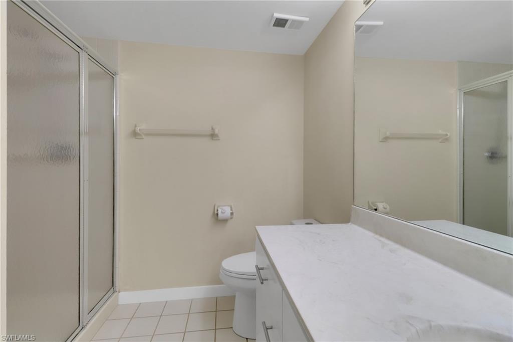 7779 Jewel Lane, Unit 103 Naples, FL 34109 - Photo 18 of 26 a bathroom with a granite countertop toilet and a shower