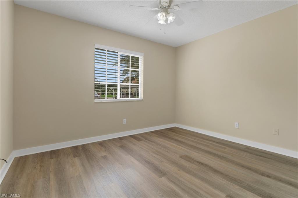 7779 Jewel Lane, Unit 103 Naples, FL 34109 - Photo 19 of 26 a view of an empty room with wooden floor and a window