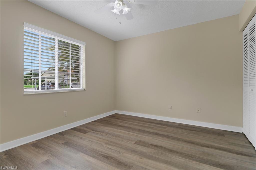7779 Jewel Lane, Unit 103 Naples, FL 34109 - Photo 20 of 26 a view of an empty room with wooden floor and a window