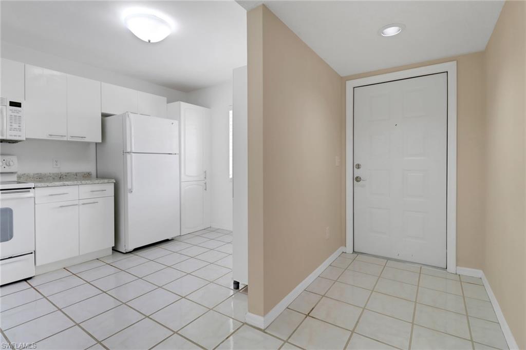 7779 Jewel Lane, Unit 103 Naples, FL 34109 - Photo 2 of 26 a view of a kitchen with white cabinets
