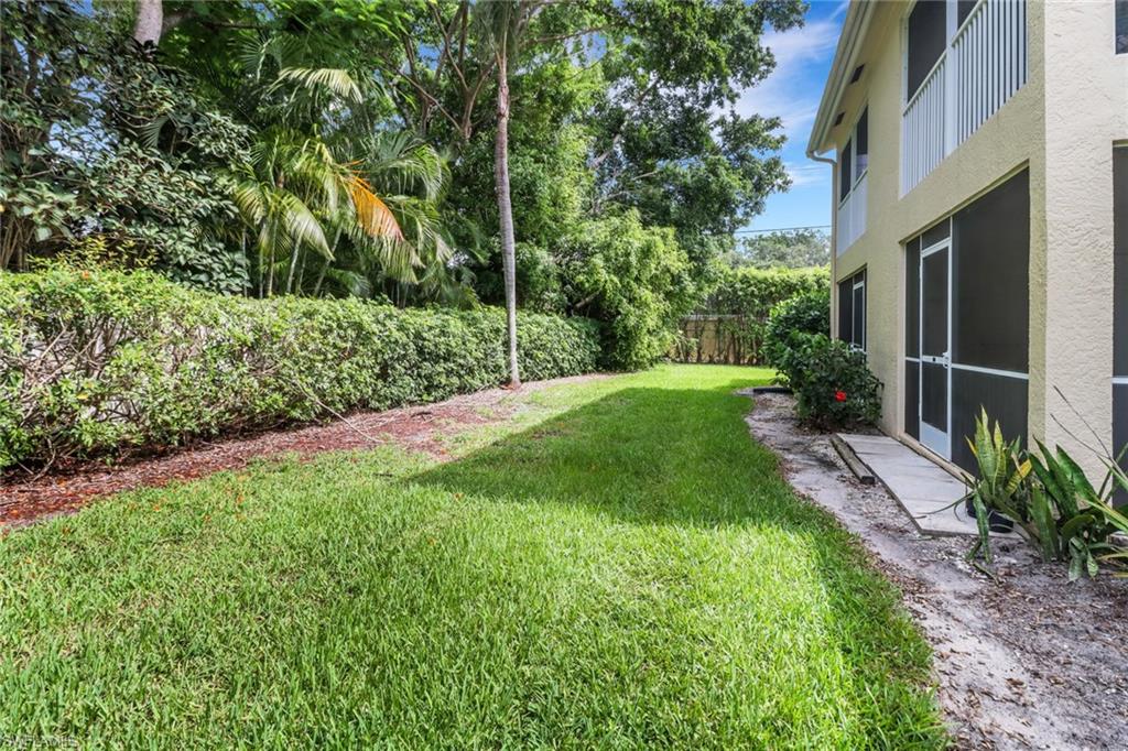 7779 Jewel Lane, Unit 103 Naples, FL 34109 - Photo 25 of 26 a view of a backyard with potted plants and large trees
