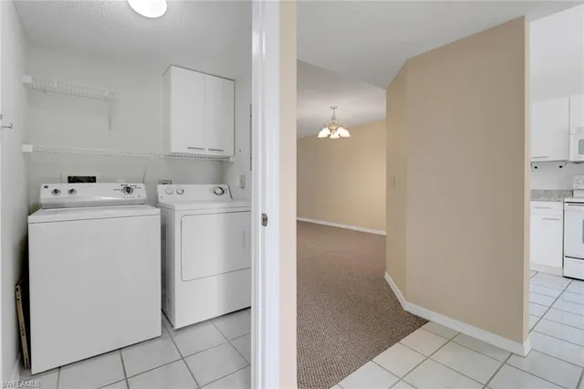 a utility room with cabinets washer and dryer