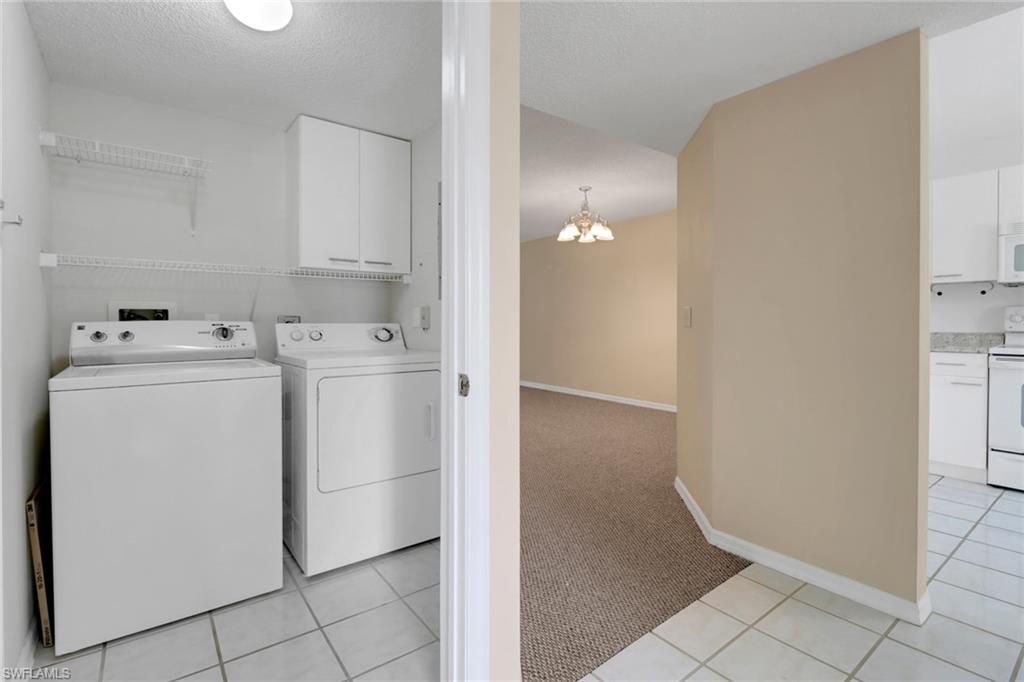 7779 Jewel Lane, Unit 103 Naples, FL 34109 - Photo 3 of 26 a utility room with cabinets washer and dryer