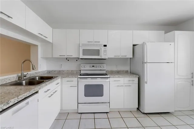 a white kitchen with sink and white stainless steel appliances