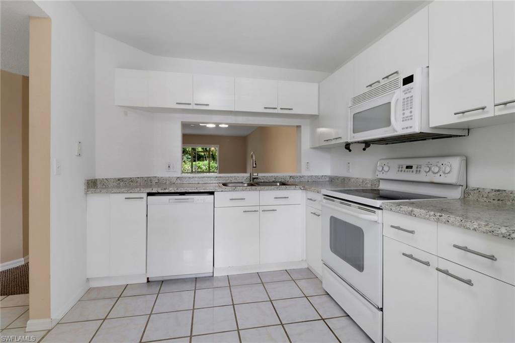 7779 Jewel Lane, Unit 103 Naples, FL 34109 - Photo 5 of 26 a kitchen with white cabinets appliances and a sink