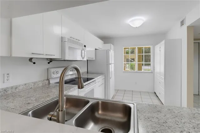 a kitchen with a sink and a stove top oven