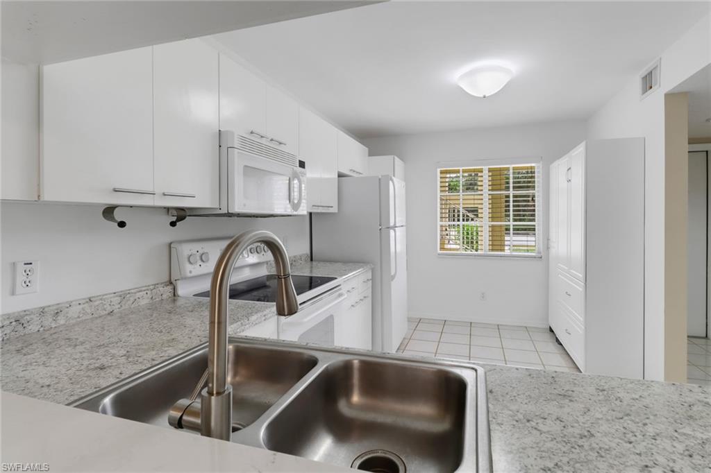 7779 Jewel Lane, Unit 103 Naples, FL 34109 - Photo 7 of 26 a kitchen with a sink and a stove top oven