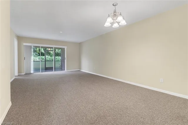 en empty room with windows and chandelier