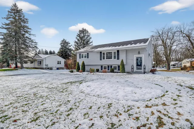 a view of a white house with a snow on the road